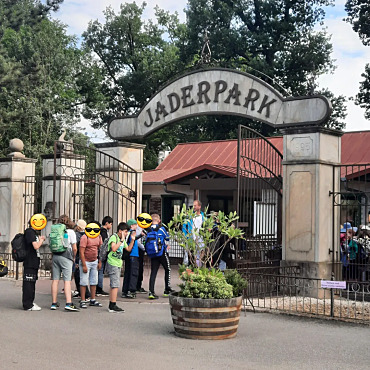 Hier ist eine Gruppe Schüler zu sehen, die vor dem Eingang des Freizeitparks warten.