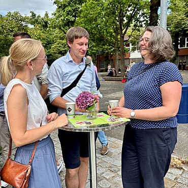 Hier sind Eltern zu sehen, die sich unterhalten und Kaffee trinken.