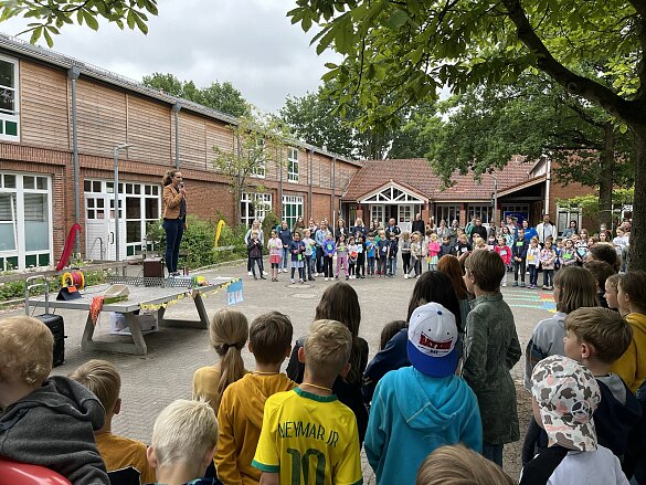 Hier ist die Schulleiterin zu sehen, die das Sommerfest eröffnet.