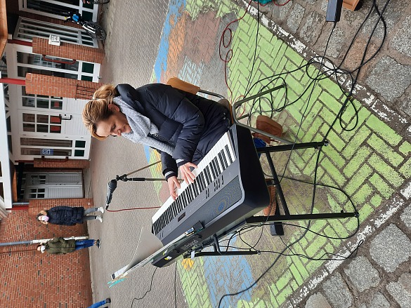 Hier ist eine Musiklehrerin zu sehen, die Klavier spielt.