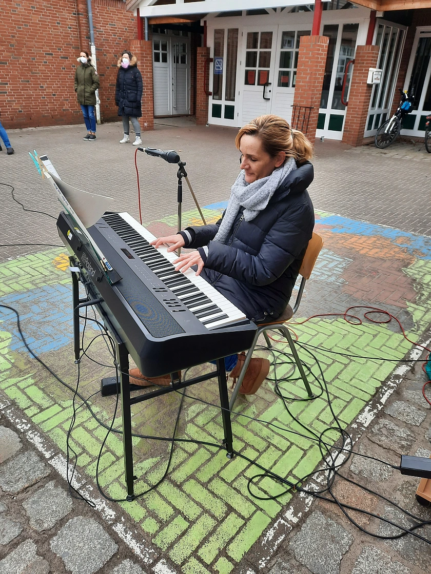 Hier ist eine Musiklehrerin zu sehen, die Klavier spielt.