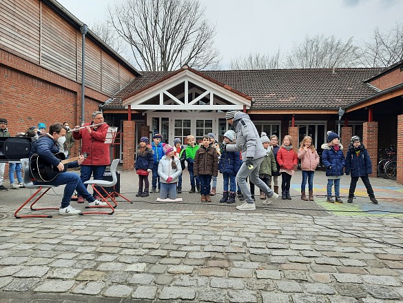 Hier ist eine Schulklasse zu sehen, die ein Lied vorträgt.