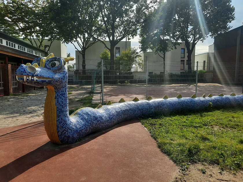 Hier ist ein Bild des Drachen zu sehen, der auf dem Schulhof steht.