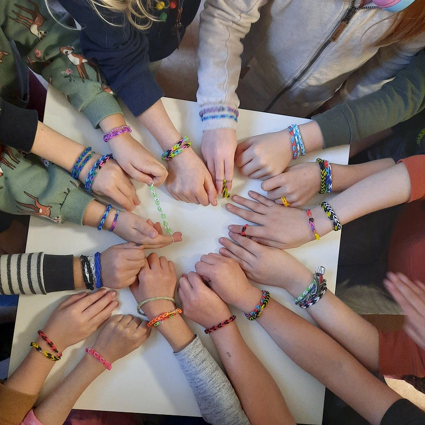 Auf diesem Bild sind viele Hände zu sehen, die einen Kreis bilden.