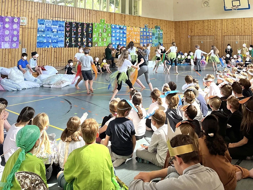 Hier ist eine Schulklasse zu sehen, die einen Tanz aufführt.