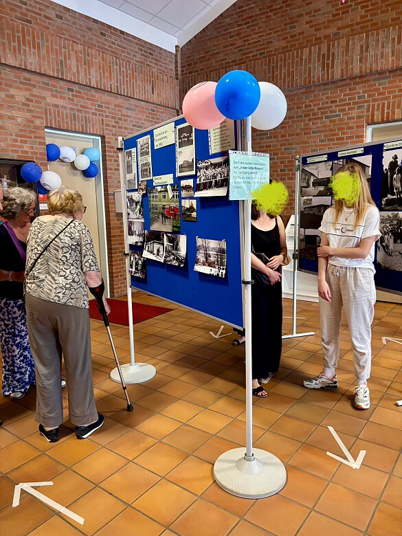 Auf dem Bild sind Menschen zu sehen, die sich die Fotowände ansehen.