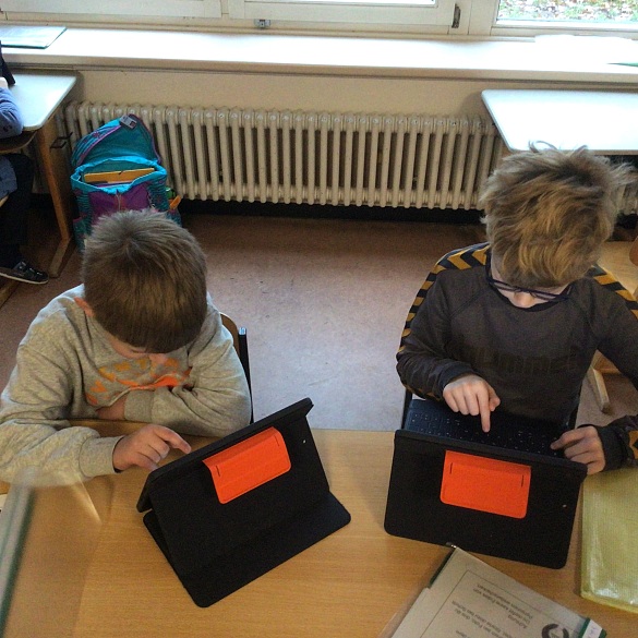 Auf diesem Bild sieht man Schüler, die am Ipad arbeiten.