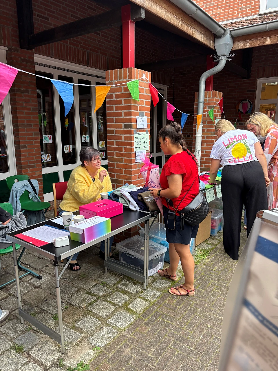 Hier sind Menschen zu sehen, die den Stand des Schulvereins betreuen.