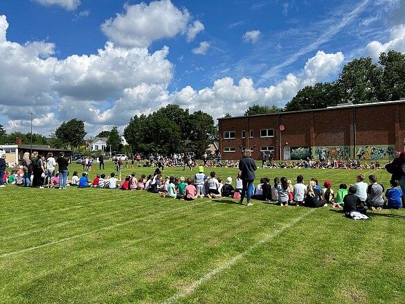 Hier ist zu sehen, wie Kinder ihre Mitschüler beim Staffellauf anfeuern.