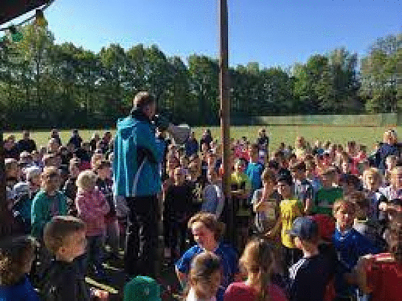 Hier ist ein Sportlehrer mit einem Megaphon zu sehen.