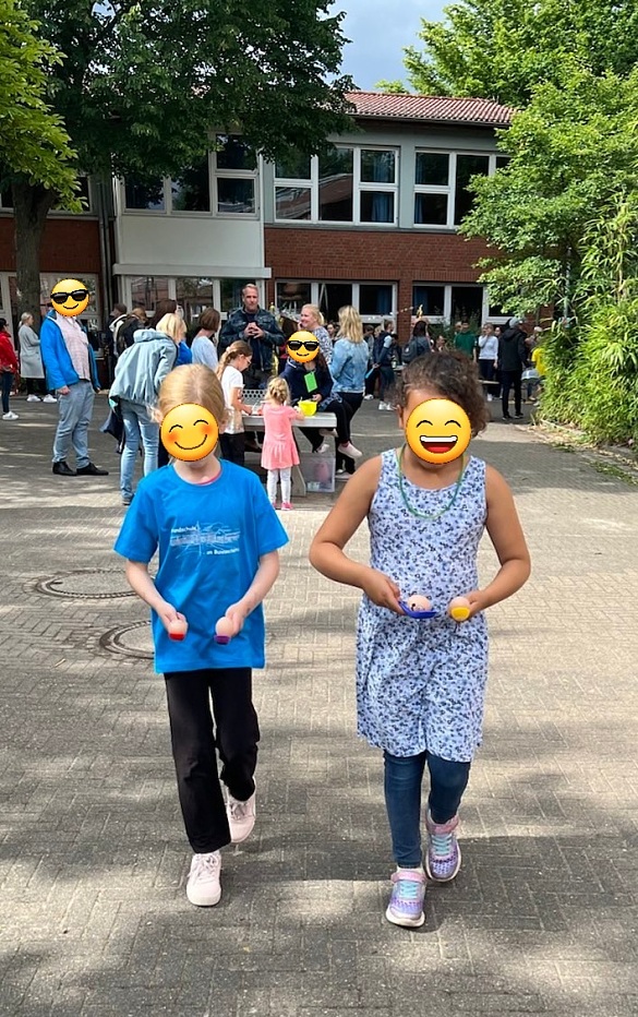 Hier sind zwei Kinder bei einem Spiel auf dem Sommerfest zu sehen.