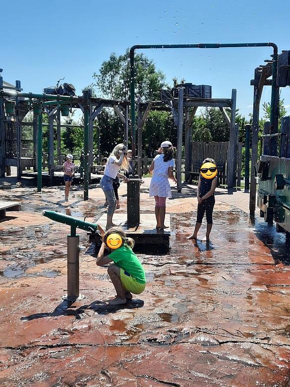 Hier sind Schüler zu sehen, die auf einem Wasserspielplatz spielen.